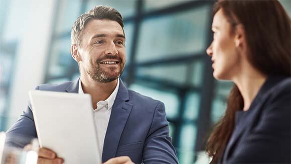 woman smiling in office looking at salary report woman smiling in office looking at salary report