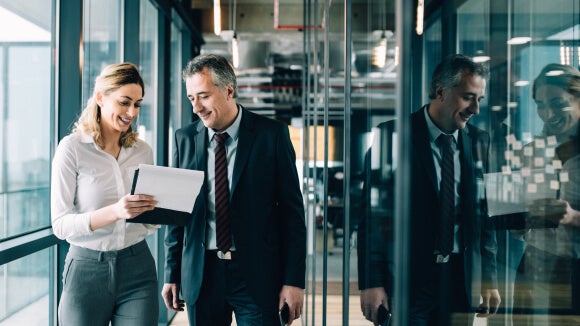 woman smiling in office looking at salary report woman smiling in office looking at salary report