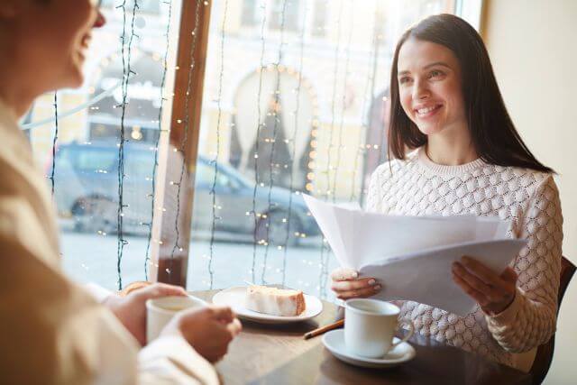 woman smiling in office looking at salary report woman smiling in office looking at salary report