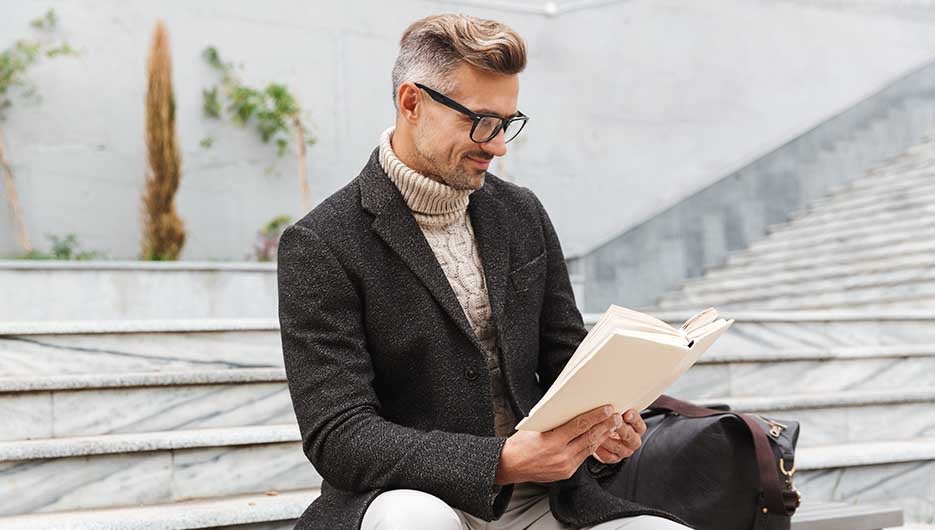 ejecutivo leyendo en unas escaleras