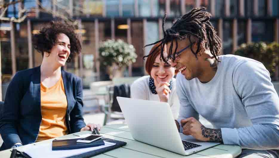 A group of young businesspeople using laptop in courtyard, start-up concept.